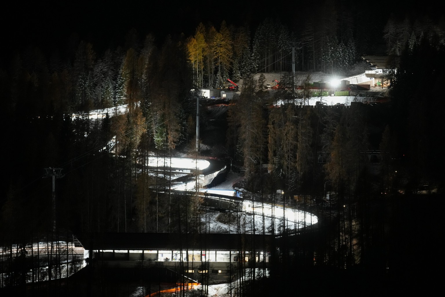 A night view of the Eugenio Monti sliding track during a three day skeleton and bobsled World Cup stage and Olympic test event in Cortina D'Ampezzo, Friday, Nov. 21, 2025. (AP Photo/Andrew Medich ...