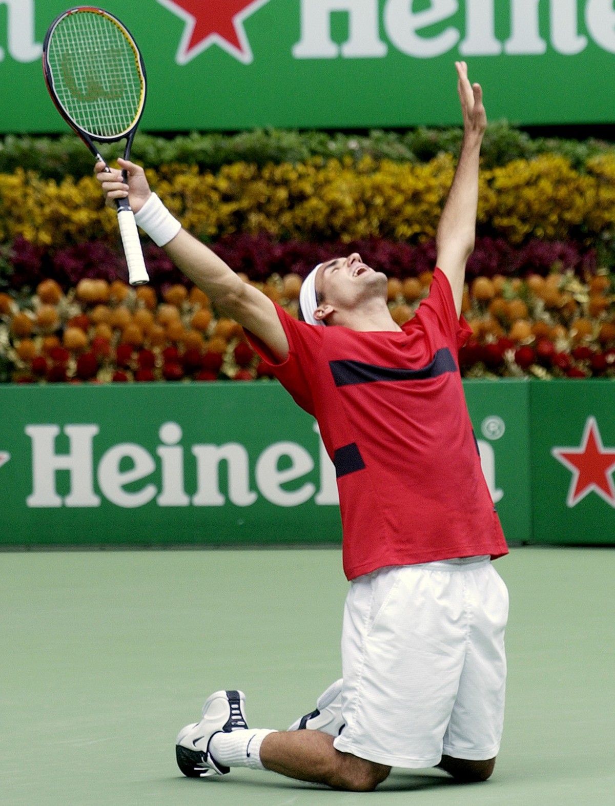 Switzerland's Roger Federer falls to his knees as he celebrates his win over Russia's Marat Safin in the men's singles final of the Australian Open in Melbourne, Australia, Sunday, Feb. ...