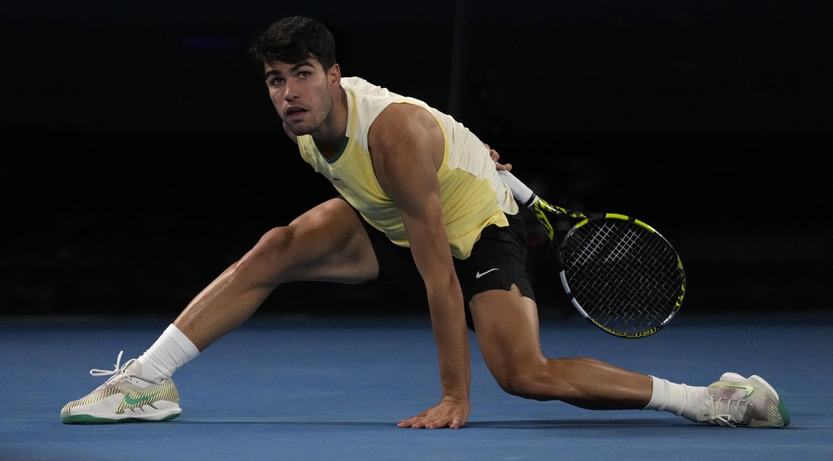 Carlos Alcaraz of Spain watches his shot to Alexander Zverev of Germany during their quarterfinal match at the Australian Open tennis championships at Melbourne Park, Melbourne, Australia, Wednesday,  ...