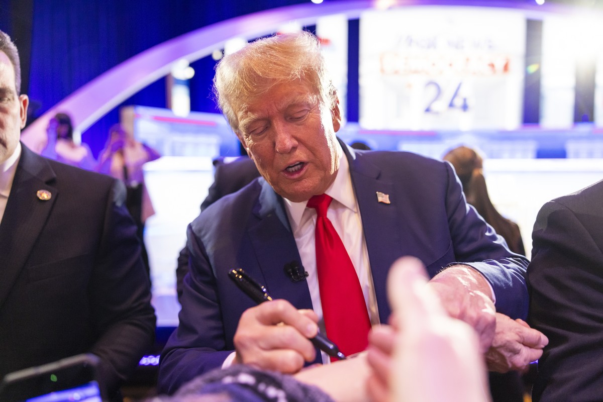 epa11068473 Former President Donald Trump signs a supporter's arm after speaking at an Iowa town hall, moderated by Fox News Channel's Bret Baier and Martha MacCallum, in the Iowa Events Cen ...