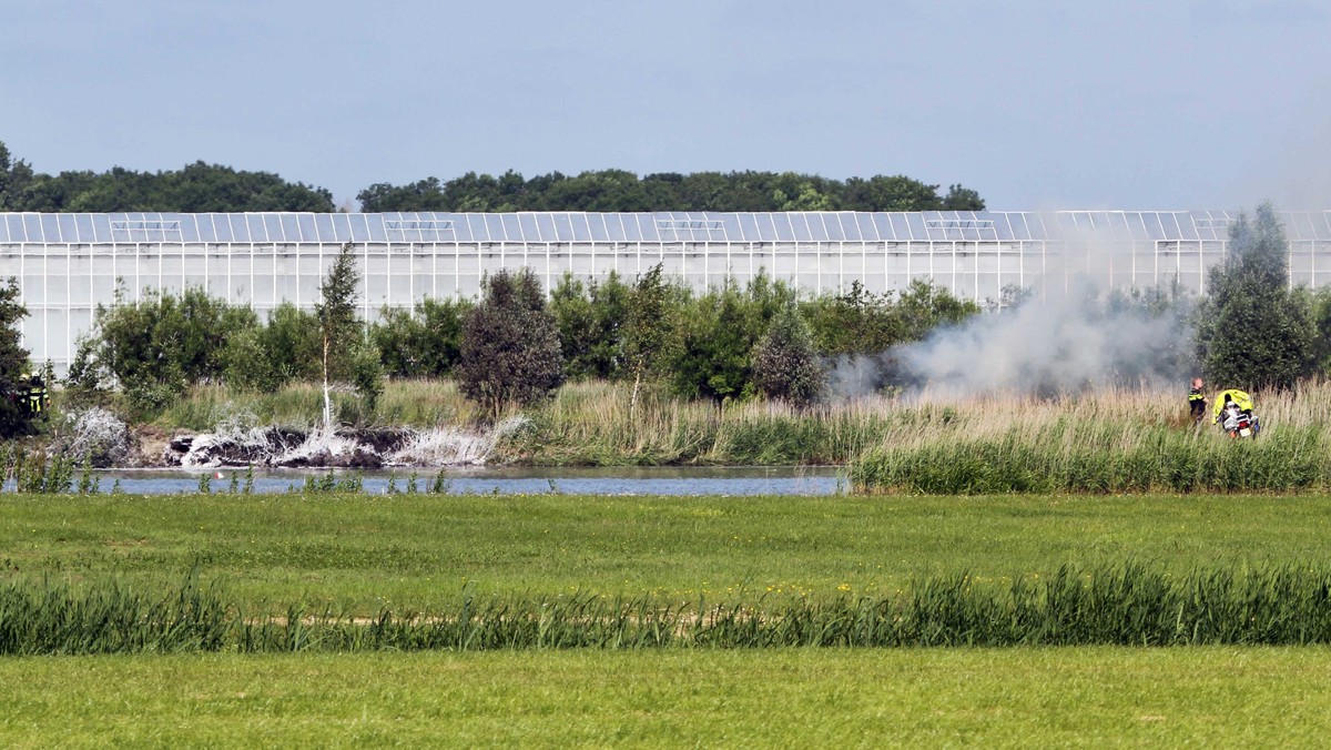 epa05353306 A view of the crash site of the A F-5 plane of Swiss stunt team Patrouille Suisse that crashed next to a greenhouse complex in Bitgum, The Netherlands, 09 June 2016. The pilot ejected hims ...