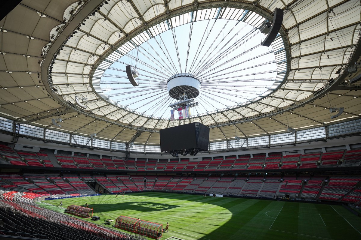 FILE - Stadium staff prepare temporary grass that was laid on top of artificial turf at BC Place stadium for a friendly soccer match between MLS soccer's Vancouver Whitecaps and League One's ...