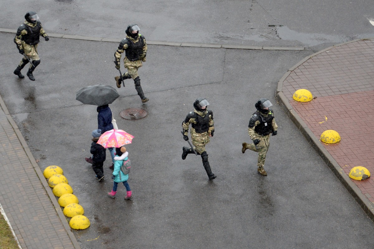 epa08850702 Belarusian policemen run during a rally against the government and President Lukashenko in Minsk, Belarus, 29 November 2020. Opposition activists continue their protest actions, demanding  ...