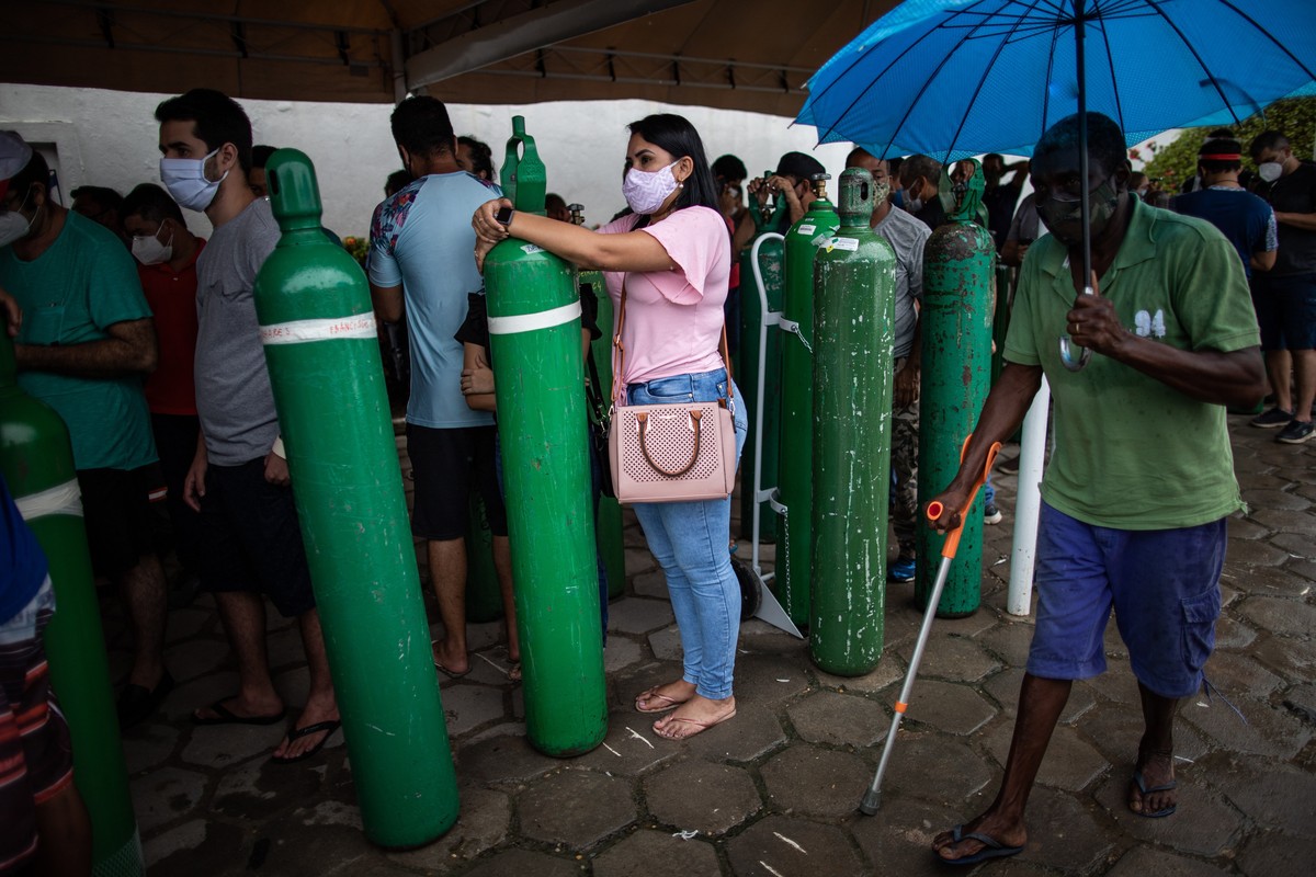 epa08949847 Relatives of patients infected with Covid-19 wait for hours since early in the morning to refill their oxygen cylinders at the Carboxi company, in Manaus, Amazonas, Brazil, on 19 January 2 ...