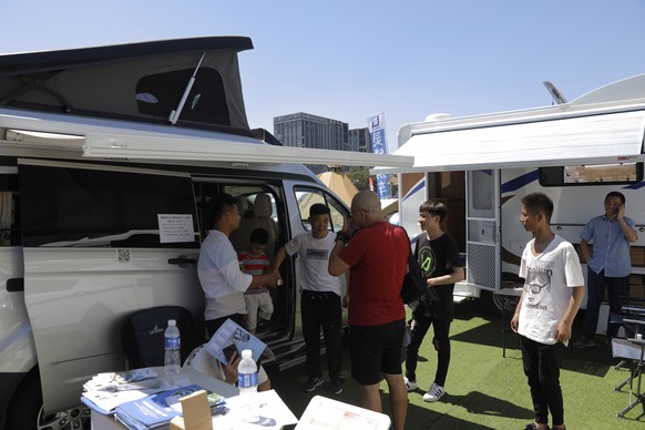 epa07647315 Chinese visitors view recreational vehicles at the All in CARAVANING expo in Beijing, China, 14 June 2019. The three-day expo is held from 14 to 16 June and exhibits many kinds of recreati ...