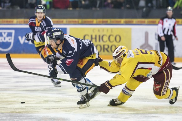 Zugs Carl Klingberg, links, kaempft um den Puck gegen Servettes Daniel Vukovic, rechts, im ersten Eishockey Playoff-Viertelfinalspiel der National League A zwischen dem EV Zug und dem Geneve-Servette  ...