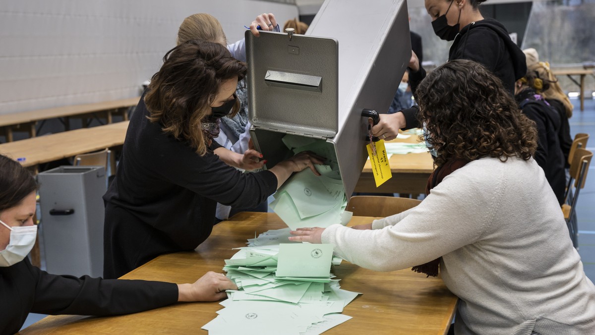 Stimmenzaehlerinnen leeren die Wahlzettel aus einer Wahlurne auf den Tisch zur Auszaehlung der Regierungs- und Grossratswahlen, am Sonntag, 27. Maerz 2022 in der Sporthalle Weissenstein in Bern. Das S ...