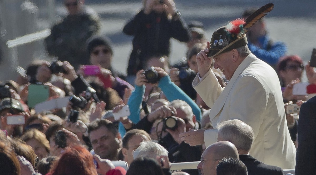 Pope Francis wears an Italian Alpine troops hat he was offered while touring St. Peter's Square at the Vatican prior to the start of his weekly general audience, Wednesday, March 5, 2014. The pon ...