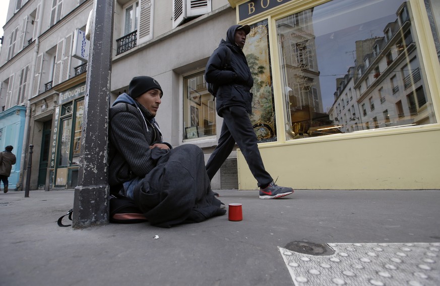 A homeless person begs, sitting in front of a bakery, in Paris, France, Monday, Nov. 24, 2014, as France’s homeless problem appears particularly acute. During his election campaign President Francois  ...