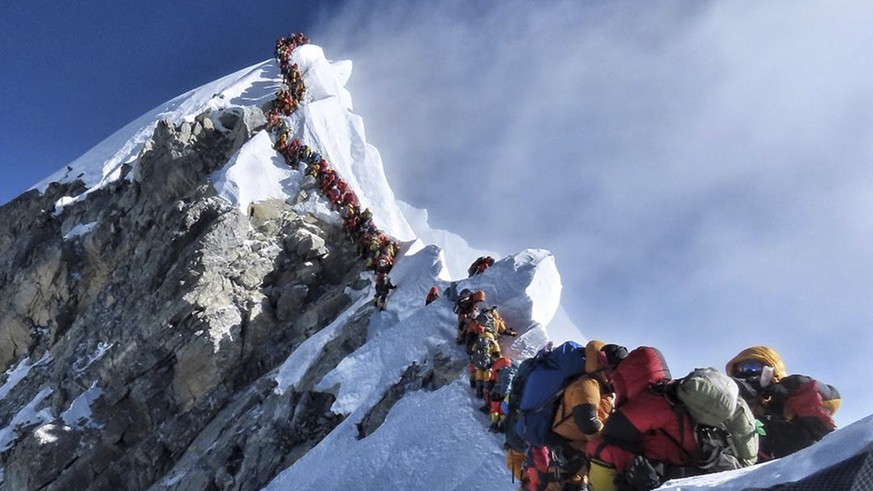 In this photo made on May 22, 2019, a long queue of mountain climbers line a path on Mount Everest. About half a dozen climbers died on Everest last week most while descending from the congested summi ...