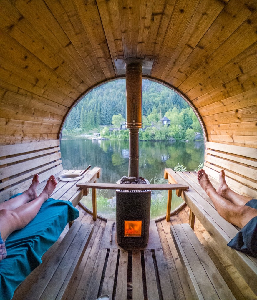 A Couple enjoys an authentic sauna experience with fire stove in Lofoten, Norway