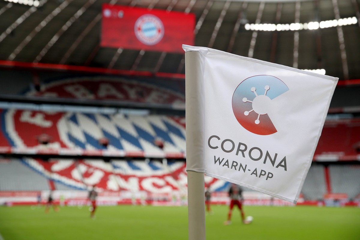 epa08497898 A corner flag with the sign for the 'Corona Warn-App' is seen during the German Bundesliga soccer match between Bayern Munich and SC Freiburg in Munich, Germany, 20 June 2020. EP ...