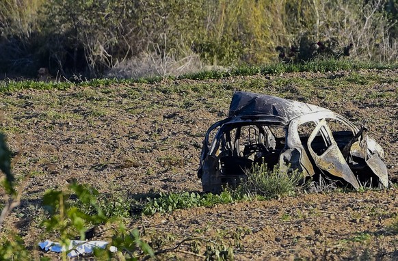 The wreckage of the car of investigative journalist Daphne Caruana Galizia lies next to a road in the town of Mosta, Malta, Monday, Oct. 16, 2017. Malta's prime minister says a car bomb has kille ...