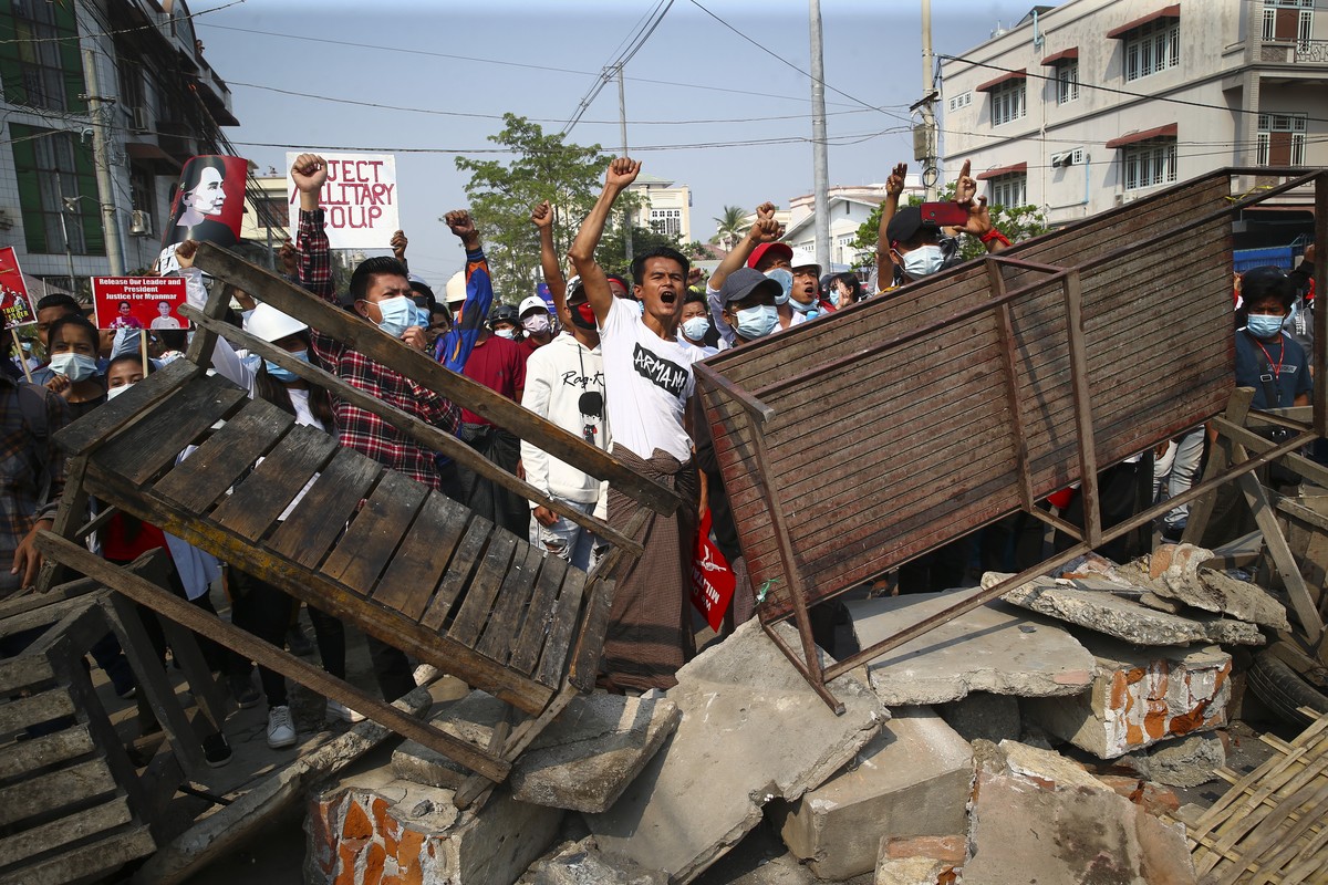 Protesters shout slogans as police arrive during a protest against the military coup in Mandalay, Myanmar, Sunday, Feb. 28, 2021. Police in Myanmar escalated their crackdown on demonstrators against t ...