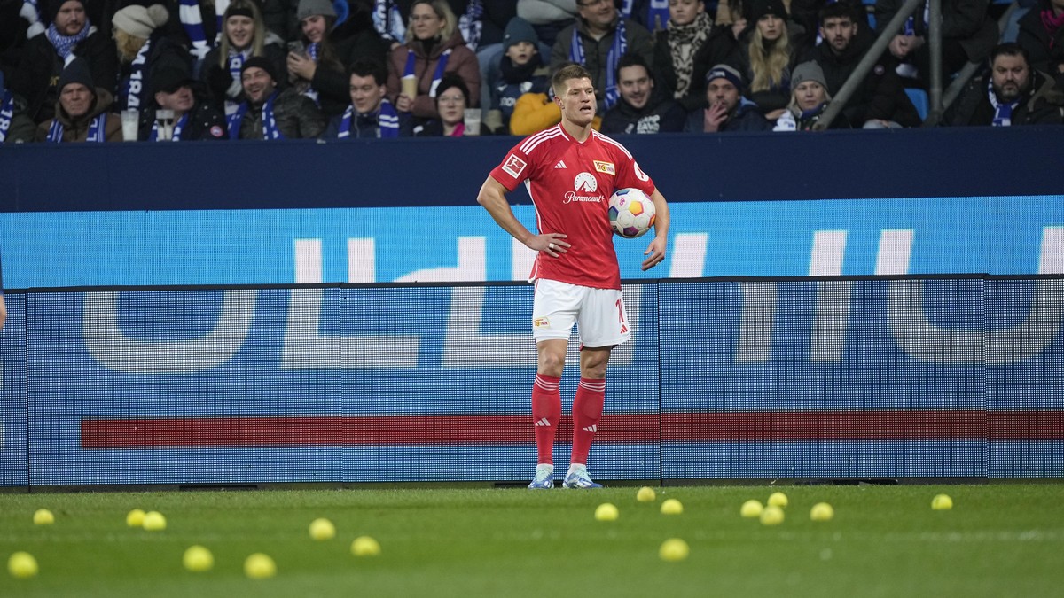 Union's Kevin Behrens stands between tennis balls on the pitch, thrown by Union fans to protest against investors, during the German Bundesliga soccer match between VfL Bochum and Union Berlin in ...