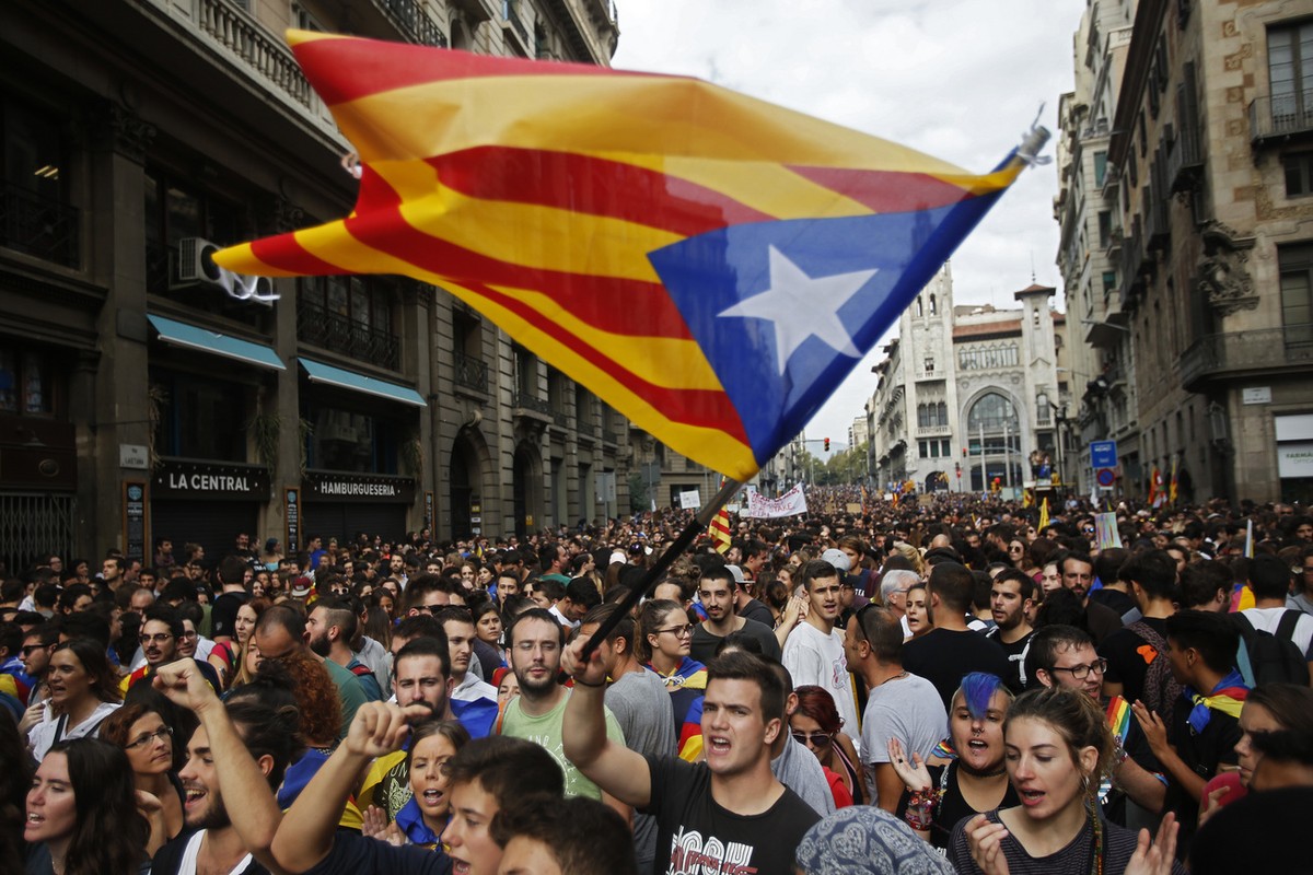 Demonstrators with "estelada", or Catalonia independent flag, gather in protest in front of the Spanish police station in Barcelona, Spain, Tuesday, Oct. 3, 2017. Labor unions and grassroots ...