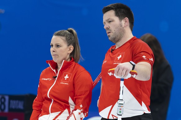 Jenny Perret, left, and Martin Rios of Switzerland team reacts during curling mixed doubles preliminary round game between Switzerland and Great Britain at the 2022 Olympic Winter Games in Beijing, Ch ...