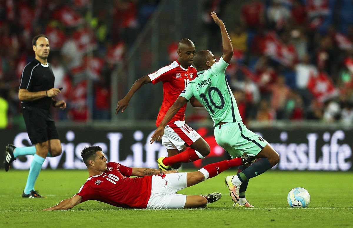 epa05527837 Swiss player Granit Xhaka (L) tackles Portugal's Joao Mario (R) during the FIFA World Cup 2018 group B qualifying soccer match between Switzerland and Portugal at the St. Jakob-Park s ...