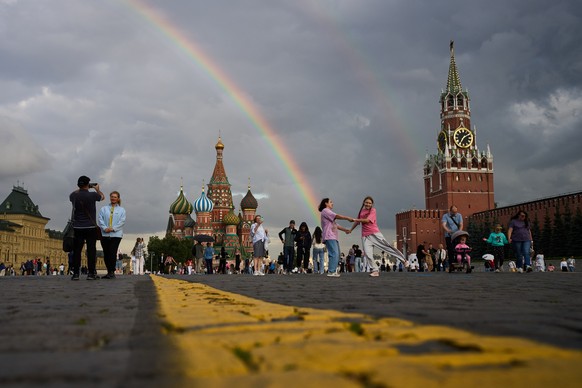 People enjoy a golden hour and rainbow as they walk in Red Square in Moscow, Thursday, July 23, 2026, backdropped by the St. Basil's Cathedral, center, and the Spasskaya Tower, right. (AP Photo/A ...