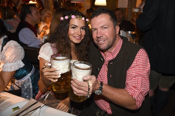 epa04419319 German former soccer player Lothar (R) Matthaeus an his fiancee Anastasia Klimko toast at the Kaefer festival tent during the 181st Oktoberfest in Munich, Germany, 26 September 2014. The a ...