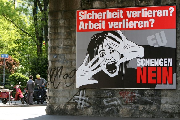 Zwei Maenner begutachten am Dientstag, 10. Mai 2005 in Zuerich eine Vespa hinter der Kulisse eines riesigen Schengen-Nein Plakates. (KEYSTONE/Alessandro Della Bella)