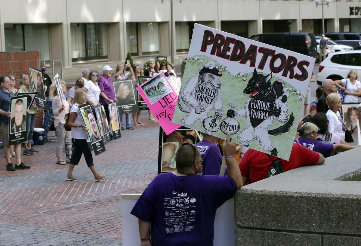Protesters gather outside a courthouse on Friday, Aug. 2, 2019, in Boston, where a judge was to hear arguments in Massachusetts' lawsuit against Purdue Pharma over its role in the national drug e ...
