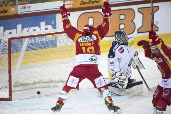 Langnaus Pascal Berger, links, und Raphael Kuonen, rechts, jubeln neben Ambris Goalie Benjamin Conz, Mitte, waehrend dem Meisterschaftsspiel der National League zwischen den SCL Tigers und dem HC Ambr ...