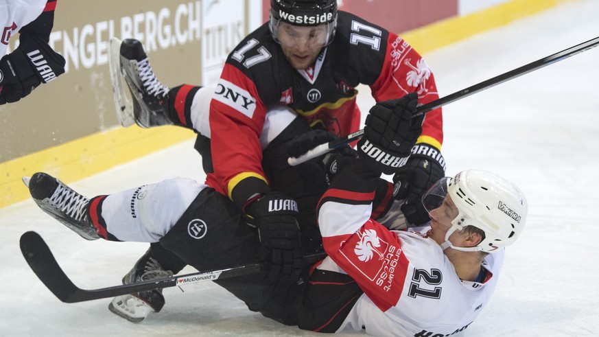 Bern&#039;s Gian-Andrea Randegger, left, fights for the puck with Jyvaeskylae&#039;s Valtteri Hotakainen, right, during a Champions Hockey League round of 16 match between Switzerland&#039;s SC Bern a ...