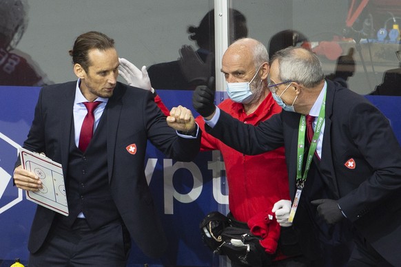 epa09221218 Patrick Fischer, left, head coach of Switzerland national ice hockey team, Karl Mueller, center, Physiotherapist of Switzerland national ice hockey team, and Jean-Claude Kuettel, right, do ...