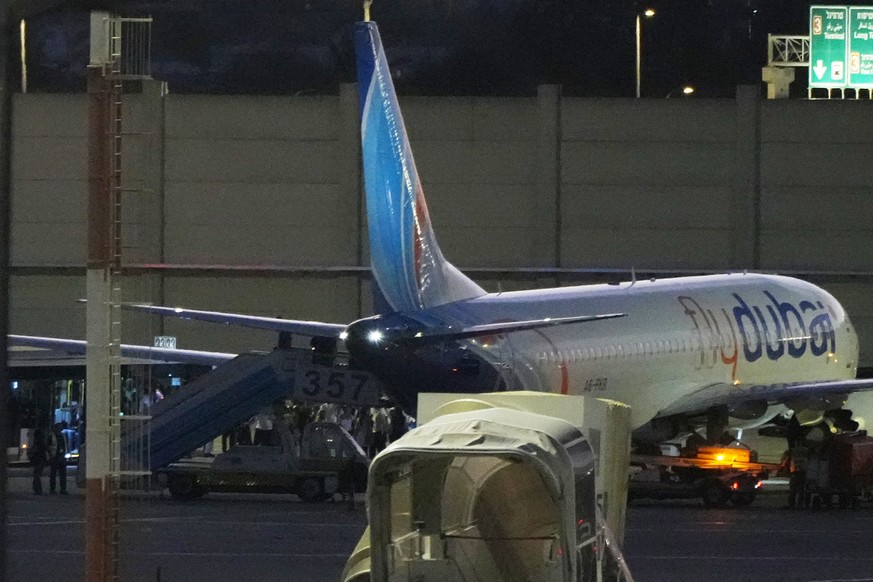 People disembark from a FlyDubai carrying Israeli passengers who had earlier been aboard another FlyDubai aircraft that made an emergency landing in Saudi Arabia approaches Ben Gurion International Ai ...