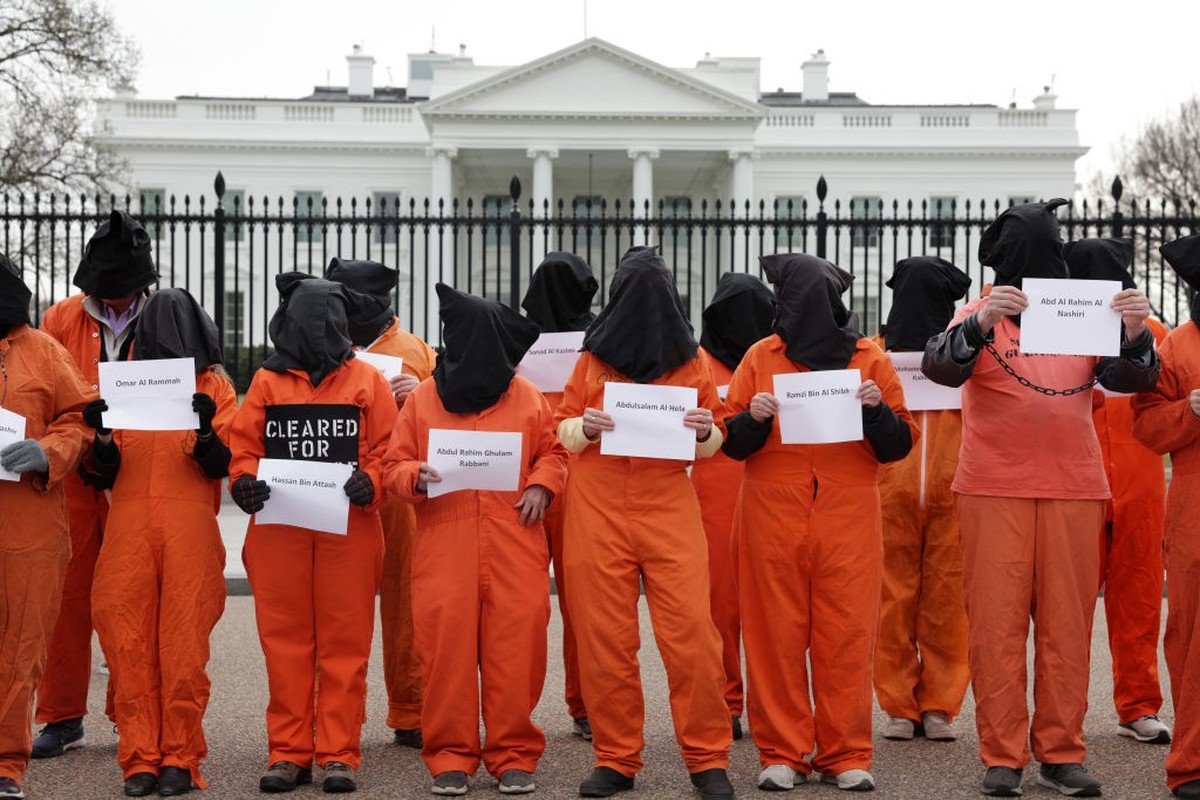 WASHINGTON, DC - JANUARY 11: Activists in orange jumpsuits, representing the 35 men who are still being held at the U.S. detention facility in Guantanamo Bay, Cuba, participate in a protest in front o ...