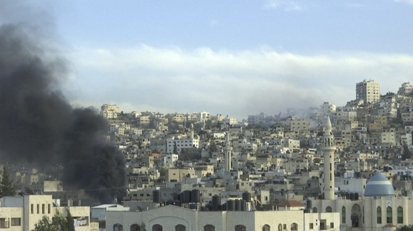 Smoke rises from buildings following Israeli raid in the occupied West Bank refugee camp of Jenin on Tuesday, March 7, 2023. Israeli military officials, speaking on condition of anonymity to discuss e ...