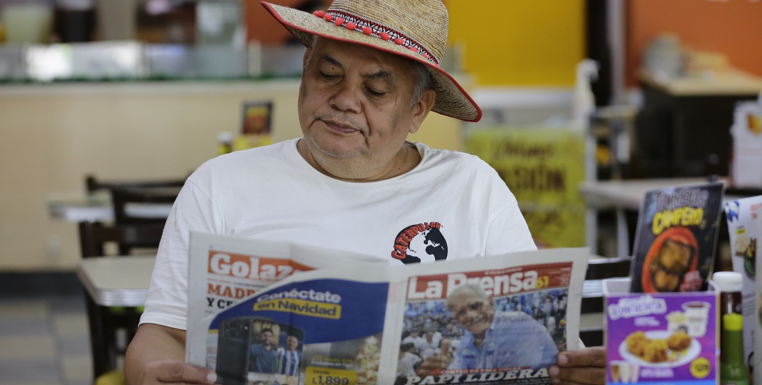 epa12562590 A man reads Honduran local newspaper &#039;La Prensa&#039; in Tegucigalpa, one day after the general elections, 01 December 2025. According to the National Electoral Council (CNE), conserv ...