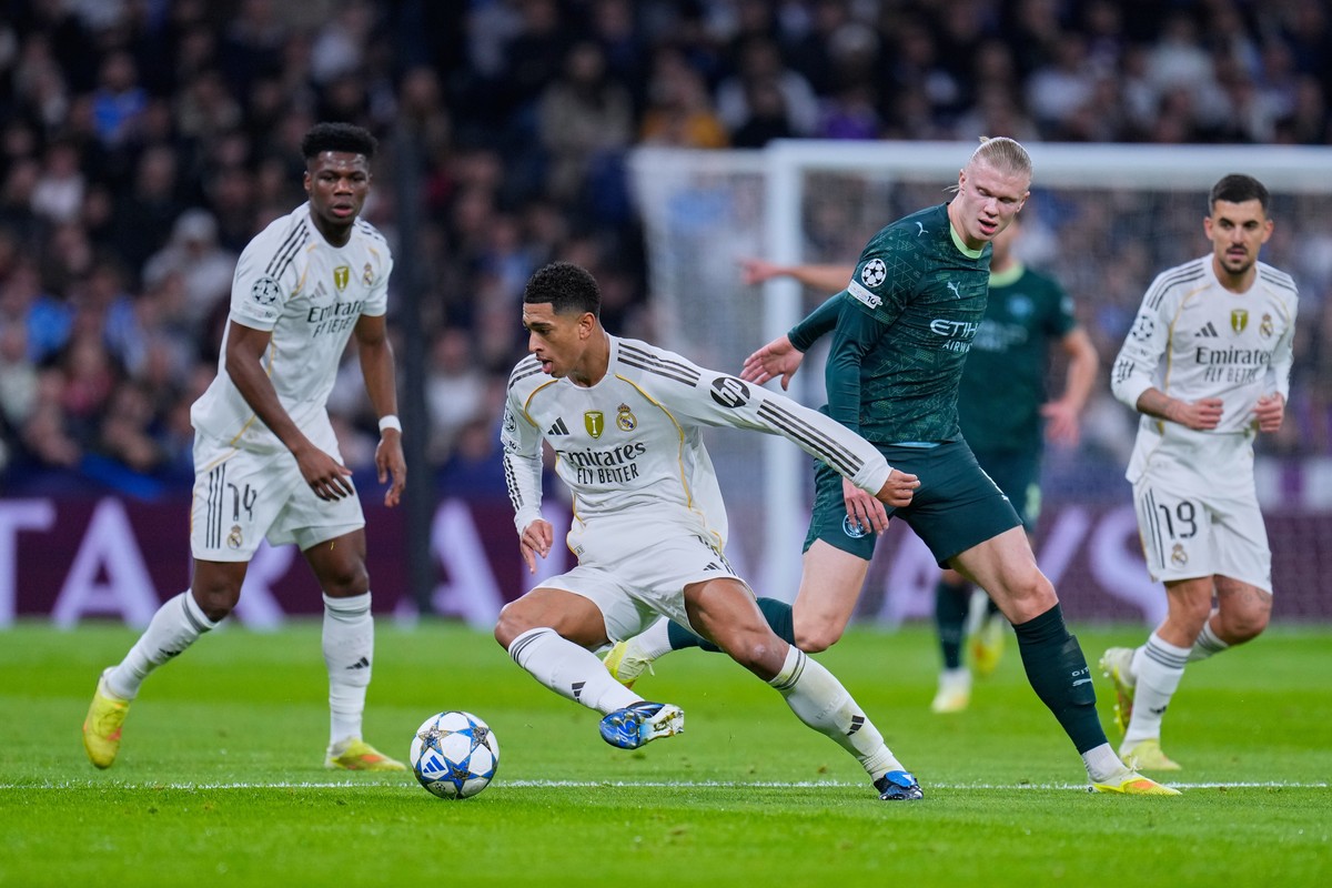 Real Madrid's Jude Bellingham, left, tussles for the ball with Manchester City's Erling Haaland during a Champions League opening phase soccer match between Real Madrid and Manchester City,  ...