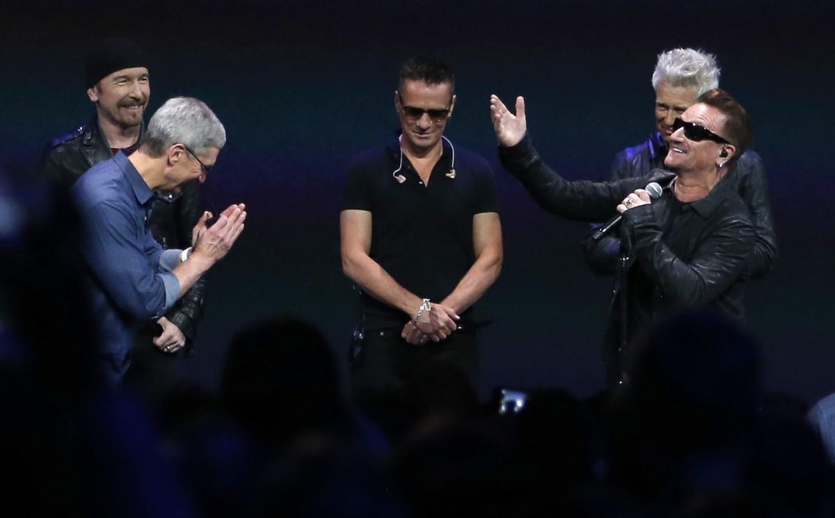 epa04393170 Apple CEO Tim Cook (L) talks with lead singer Bono (R) and members of the Irish group U2 during Apple's launch event at the Flint Center for the Performing Arts in Cupertino, Californ ...