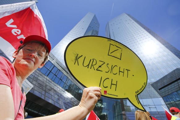 An employee of Postbank, member of German union Verdi, protests during a warning strike in front of the headquarters of Deutsche Bank in Frankfurt, April 24, 2015. Deutsche Bank&#039;s supervisory boa ...