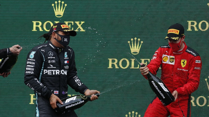 Third placed Ferrari driver Sebastian Vettel of Germany, right, pours champagne of race winner Mercedes driver Lewis Hamilton of Britain on the podium of the Formula One Turkish Grand Prix at the Ista ...