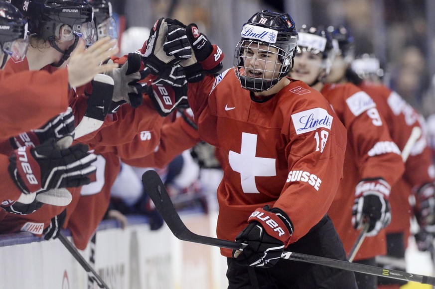 Switzerland forward Nico Hischier (18) celebrates with teammates at the bench after scoring against the United States during the third period of a quarterfinal hockey game at the world junior champion ...