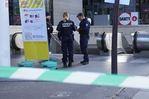 Police officers stand by a subway station after a woman allegedly made threatening remarks on a train, Tuesday, Oct. 31, 2023 in Paris. Paris police opened fire on a woman who allegedly made threateni ...