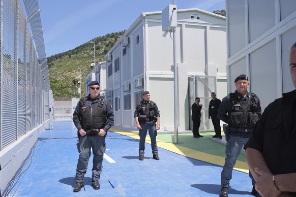 Policemen guard a reception center for migrants, at the port of Shenjin, northwestern Albania, on Wednesday, June 5, 2024. Italian Premier Giorgia Meloni is traveling to Albania Wednesday to thank the ...