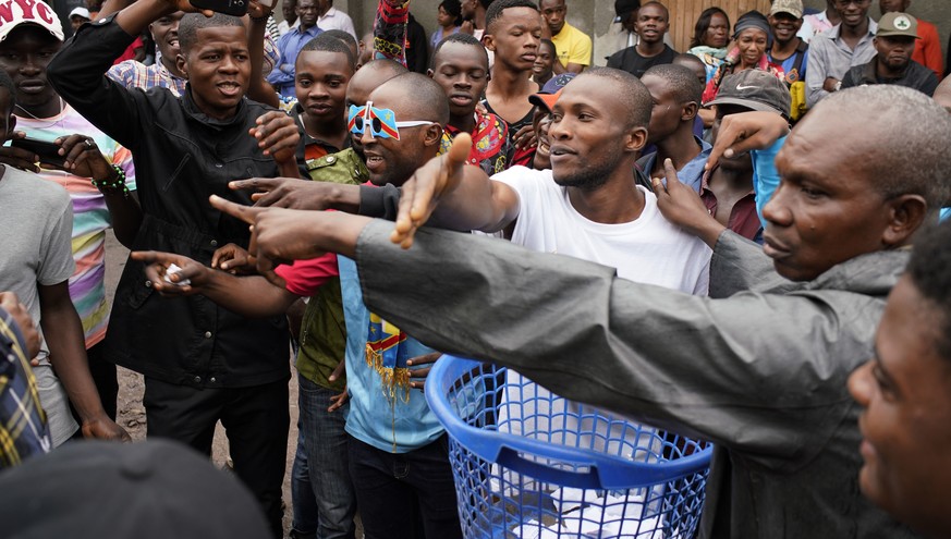 Congolese voters who have been waiting at the St. Raphael school in the Limete district of Kinshasa Sunday Dec. 30, 2018, conduct a mock ballot outside the polling station. People had started to gathe ...