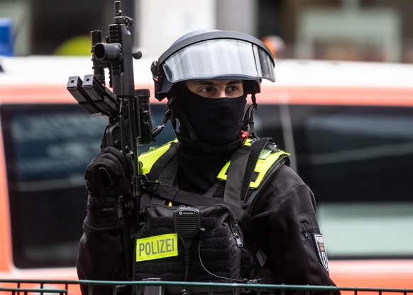 epa09228640 A police officer secures the front of a Deutche bank branch at the Johannisthaler Chaussee in Berlin, Germany, 26 May 2021. According to the police, two men were injured, including the all ...