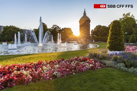 Germany, Mannheim, Friedrichsplatz with fountain and water tower in the background by sunset