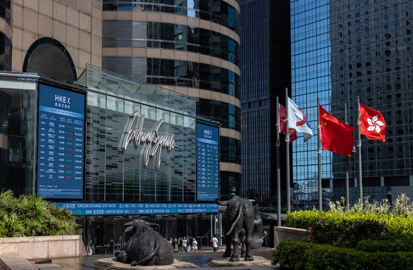 epa09323376 The Chinese and Hong Kong flags fly outside Exchange Square, the building housing the bourse, in Hong Kong, China, 05 July 2021. The Hang Seng Index fell 0.6 percent or 166 points to 28,14 ...