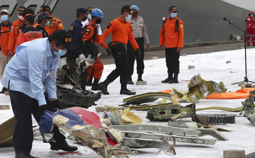 An Indonesian National Transportation Safety Committee (KNKT) investigator inspects the debris found in the waters around the location where Sriwijaya Air passenger jet crashed at Tanjung Priok Port i ...