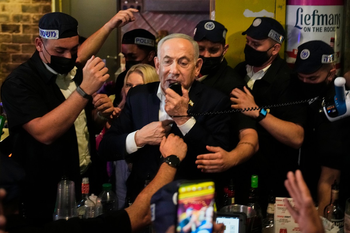 Israeli Prime Minister and Likud party leader Benjamin Netanyahu, flanked by security personnel, speaks to supporters during an election campaign visit to Jerusalem's Mahane Yehuda Market early F ...