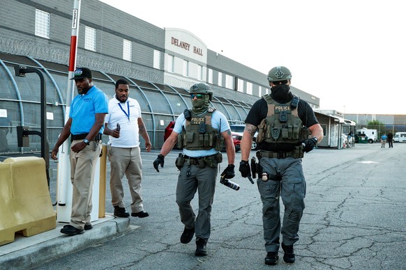 epa13149175 Immigration and Customs Enforcement (ICE) agents are seen with a can of pepper spray at the Delaney Hall Immigration Detention Facility during a vigil and protest for Edwin Jovanny Lopez C ...