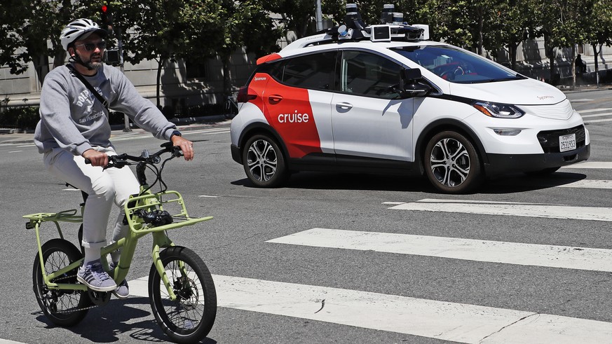 epa10796036 Cruise, a driverless robotaxi (R), drives on a street in San Francisco, California, USA, 11 August 2023. State regulators approved the expansion of Cruise and Waymo robotaxi services in a  ...