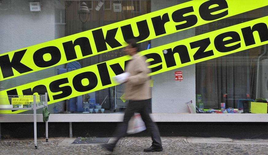 Ein Mann geht am Dienstag, 9. Juni 2009, in Berlin an einem Geschaeft mit Werbeschildern mit der Aufschrift &quot;Konkurse, Insolvenzen&quot;, das Artikel aus Geschaeftsaufloesungen verkauft, vorbei.  ...