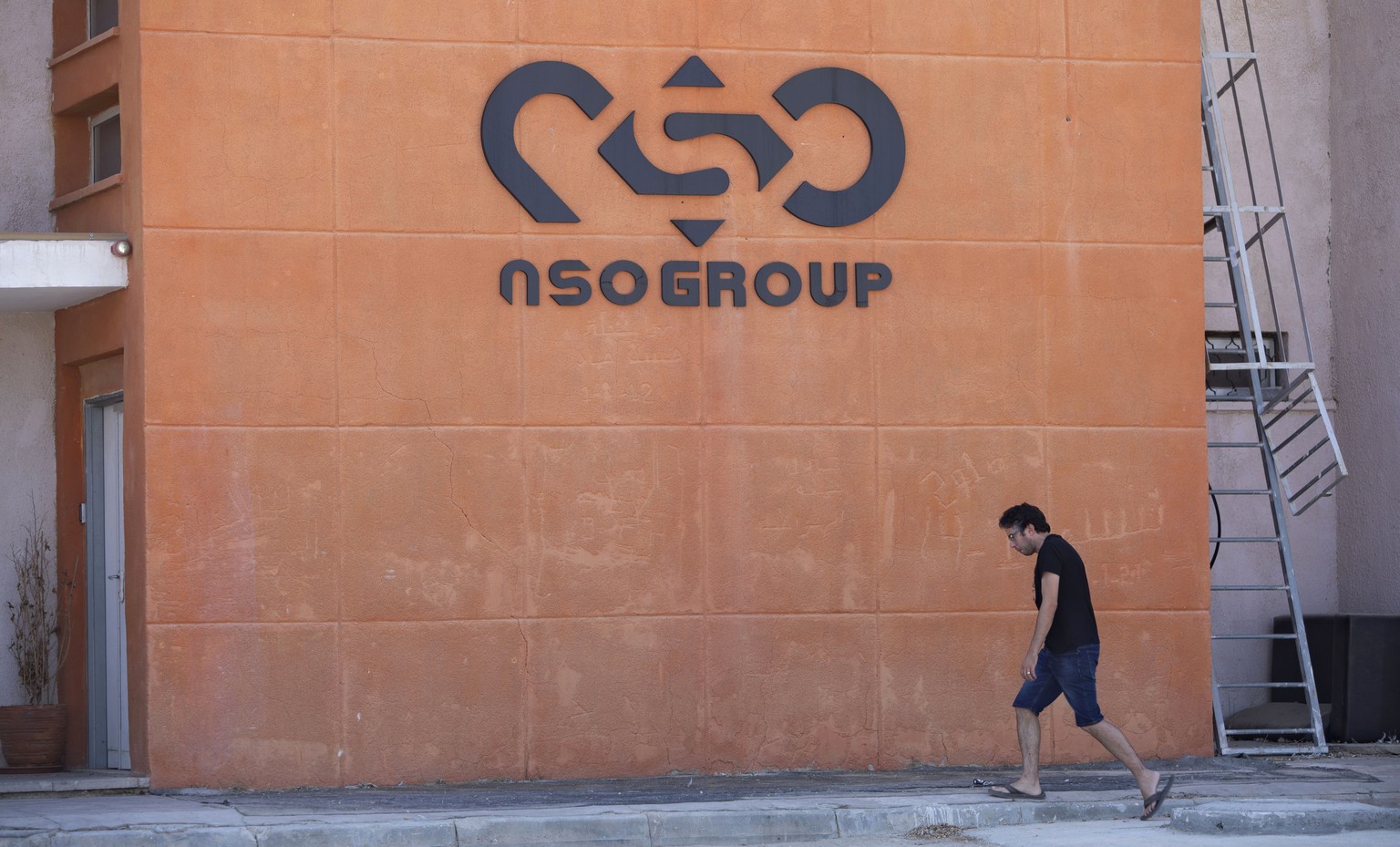 FILE - A logo adorns a wall on a branch of the Israeli NSO Group company, near the southern Israeli town of Sapir, Aug. 24, 2021. Tech giant Apple announced Tuesday, Nov. 23, that it is suing Israel�� ...
